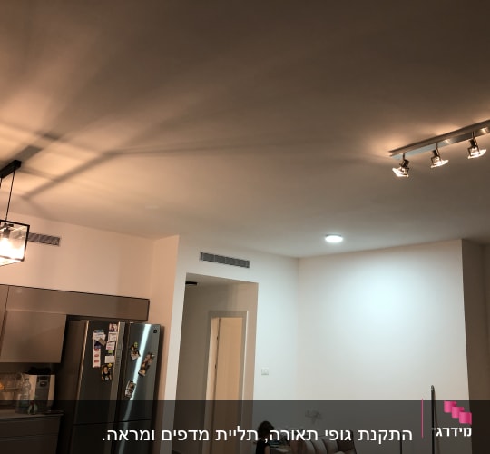 מטבח עם מקרר, כיור וכלים על השיש